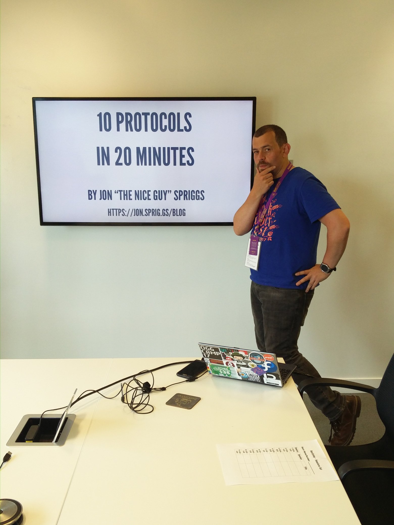 A picture of Jon Spriggs next to a projector showing '10 protocols in 20 minutes'
