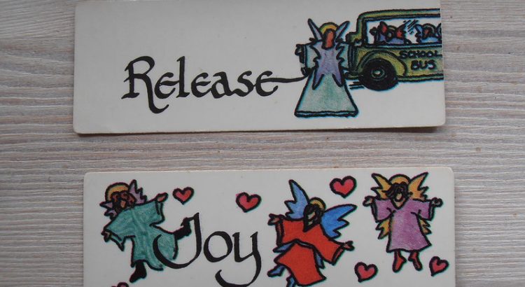 Two sheets of card, the first illustrated with an individual next to a school bus, and the word "Release" and the second with the same individual and two others, around the word "Joy" and hearts